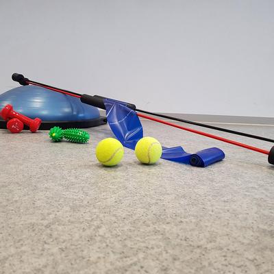 Verschiedene Trainingsgeräte: Balance-Trainer, Hanteln, Gymnastikstäbe, Tennisbälle und Theraband